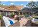 An outdoor patio with comfortable seating and a fire pit with an enclosed pool in the background at 3427 Forest Bridge Cir, Brandon, FL 33511