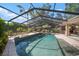 A stunning backyard pool is enclosed and surrounded by a patio with seating and lush plants at 3427 Forest Bridge Cir, Brandon, FL 33511