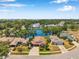 Stunning aerial view of a home nestled by a serene lake surrounded by lush trees and well-manicured lawns at 3610 Montero Ct, Sun City Center, FL 33573
