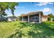 Beautiful backyard with a screened lanai, lush lawn, and mature trees offering a peaceful outdoor retreat at 3610 Montero Ct, Sun City Center, FL 33573