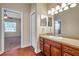 Bathroom with wood vanity and a view into a bedroom with carpet, ceiling fan, and a closet at 3610 Montero Ct, Sun City Center, FL 33573