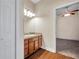 Bathroom has a wood vanity with a sink and a view into a bedroom with wood floors and ceiling fan at 3610 Montero Ct, Sun City Center, FL 33573