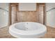 Close-up of a soaking tub surrounded by dual showers and neutral tile at 3610 Montero Ct, Sun City Center, FL 33573