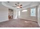 Bedroom with neutral walls, plush carpet, ceiling fan, lake views, and ensuite bathroom access at 3610 Montero Ct, Sun City Center, FL 33573