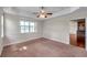 Bedroom with tan carpet, ceiling fan, and a view of the lake at 3610 Montero Ct, Sun City Center, FL 33573