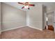 This bedroom offers neutral walls, brown carpet, ceiling fan, and closet with easy access to other rooms at 3610 Montero Ct, Sun City Center, FL 33573