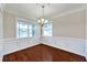 Bright dining room with wainscoting, wood floors, modern chandelier, and a view of the pond at 3610 Montero Ct, Sun City Center, FL 33573