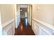 Elegant hallway featuring hardwood floors, decorative wainscoting, and inviting archways leading to living spaces at 3610 Montero Ct, Sun City Center, FL 33573