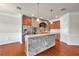 Open-concept kitchen features exposed brick archway, stainless steel appliances, and brick accent kitchen island at 3610 Montero Ct, Sun City Center, FL 33573