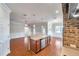 Open kitchen with center island, stainless steel appliances, exposed brick accents, and wood flooring at 3610 Montero Ct, Sun City Center, FL 33573
