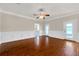 Spacious living room featuring wood floors, white wainscoting, and natural light from the glass doors at 3610 Montero Ct, Sun City Center, FL 33573