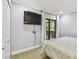 Light and airy bedroom featuring neutral walls, a TV, and access to a private balcony at 36750 Us 19 N # 06111, Palm Harbor, FL 34684