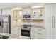 Modern kitchen with stainless steel appliances, granite counters, and glass-front cabinets with display lighting at 36750 Us 19 N # 06111, Palm Harbor, FL 34684