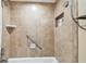 Neutral tiled shower featuring a built-in product shelf and grab bar for safety and convenience at 36750 Us 19 N # 06111, Palm Harbor, FL 34684