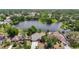 A picturesque aerial view showcases a home near a serene lake surrounded by lush greenery at 3810 Hollister Pl, Brandon, FL 33511