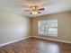 This bright bedroom features wood-look flooring, a ceiling fan and large window at 3810 Hollister Pl, Brandon, FL 33511