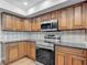 Kitchen with granite countertops, stainless steel appliances, and wood cabinets at 3810 Hollister Pl, Brandon, FL 33511