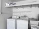 Functional laundry area in the garage with washer, dryer, utility sink and storage shelves at 3810 Hollister Pl, Brandon, FL 33511