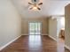 Open living room featuring wood floors, ceiling fan and sliding glass doors to the patio at 3810 Hollister Pl, Brandon, FL 33511