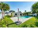 Inviting backyard features a sparkling pool, lush landscaping, and a patio umbrella for shaded relaxation at 4104 W Watrous Ave, Tampa, FL 33629