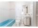 This bathroom features white tile, a blue bathtub, toilet, and sink with storage at 4104 W Watrous Ave, Tampa, FL 33629