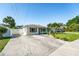 Bright exterior showcases an ample driveway, manicured lawn, and classic architecture against a clear blue sky at 4104 W Watrous Ave, Tampa, FL 33629