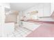 Spacious kitchen featuring white cabinets, pink countertops, and tiled flooring at 4104 W Watrous Ave, Tampa, FL 33629