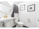 Modern half bathroom featuring pedestal sink, toilet, and decorative wall art at 4137 Northmeadow Cir, Tampa, FL 33618