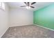 Spacious bedroom with neutral carpet and a ceiling fan, complemented by a vibrant accent wall at 4137 Northmeadow Cir, Tampa, FL 33618
