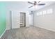 Bright bedroom with closet space featuring sliding doors, neutral carpet, and a ceiling fan at 4137 Northmeadow Cir, Tampa, FL 33618