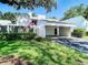 Bright home with white facade, carport, modern privacy fence, tidy landscaping, and an American flag at 4137 Northmeadow Cir, Tampa, FL 33618