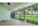Screened patio features a ceiling fan, tiled flooring, and serene green scenery at 4137 Northmeadow Cir, Tampa, FL 33618