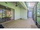 Tiled screened patio featuring ceiling fan and offering glimpses of the lush green surroundings at 4137 Northmeadow Cir, Tampa, FL 33618