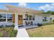 Inviting front porch featuring a seating area, wooden front door, and manicured landscaping at 4219 26Th N Ave, St Petersburg, FL 33713