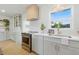 Modern kitchen with white cabinets, stainless steel range, designer hood, and a window over the sink at 4219 26Th N Ave, St Petersburg, FL 33713