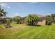 Expansive backyard featuring tropical landscaping, a lush lawn, and a screened-in lanai at 4410 Natures Reach Ter, Parrish, FL 34219