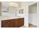 Double sink bathroom with dark wood cabinets and a large mirror at 4410 Natures Reach Ter, Parrish, FL 34219