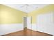 Bedroom with wood floors, chair railing, ceiling fan, closet, and white doors at 4410 Natures Reach Ter, Parrish, FL 34219