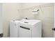 Modern laundry room with white washer and dryer and wire shelving at 4410 Natures Reach Ter, Parrish, FL 34219
