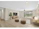 Bright living room with neutral walls, tile floor, ceiling fan, and sliding glass doors to the backyard at 4410 Natures Reach Ter, Parrish, FL 34219