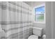 A bathroom with a shower/tub combination featuring a clean, striped shower curtain and window at 4935 W Bay Way Pl, Tampa, FL 33629
