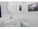 Clean and bright powder room featuring a vanity sink, toilet, wainscoting, and tasteful decor at 4935 W Bay Way Pl, Tampa, FL 33629