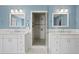 Bathroom featuring double sinks, sleek marble floors, a glass-enclosed shower, and modern fixtures at 4935 W Bay Way Pl, Tampa, FL 33629