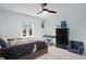 This bedroom has a fan, dark furniture, and nice light from a large window at 4935 W Bay Way Pl, Tampa, FL 33629