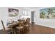 Bright dining area with hardwood floors, a wooden table with seating for six, and scenic artwork at 4935 W Bay Way Pl, Tampa, FL 33629