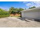 Attached two-car garage with wide driveway and well maintained landscaping along perimeter for privacy at 4935 W Bay Way Pl, Tampa, FL 33629