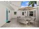Outdoor dining area with an umbrella, table, chairs, and cafe string lights on a stone paver patio at 4935 W Bay Way Pl, Tampa, FL 33629