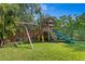 Wooden playground set featuring swings, slide, and climbing area in the backyard at 4935 W Bay Way Pl, Tampa, FL 33629