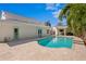 Backyard pool featuring a stone paver deck, turquoise water, and a house with a light-colored exterior at 4935 W Bay Way Pl, Tampa, FL 33629