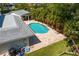 Aerial view of the backyard pool surrounded by brick pavers and lush tropical landscaping at 4935 W Bay Way Pl, Tampa, FL 33629